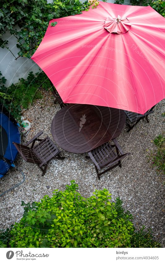 Sitzecke mit rotem Sonnenschirm im Garten aus der Vogelperspektive Stühle Tisch Pflanzen zuhause grün grau gemütlichkeit Sommer Menschenleer
