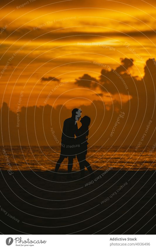 Anonymes Liebespaar, das sich bei Sonnenuntergang am Strand küsst Paar Kuss Umarmen MEER Silhouette romantisch Partnerschaft Zusammensein Natur wolkig Himmel
