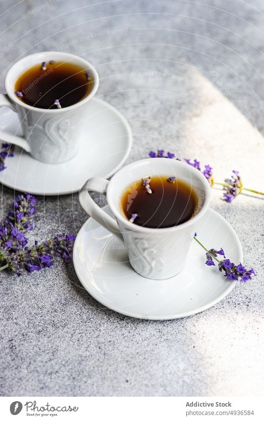 Keramische Kaffeetassen mit Lavendel Getränk schwarz Koffein Keramik Beton. Hintergrund Tasse trinken Espresso geblümt Blume Feinschmecker Morgen Becher