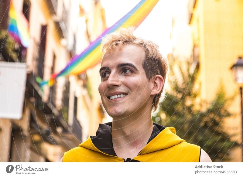 Mann auf der Straße während des LGBT-Stolz-Monats nicht binär Lächeln lgbt Glück Symbol Toleranz Haus männlich jung Transgender transsexuell Optimist heiter