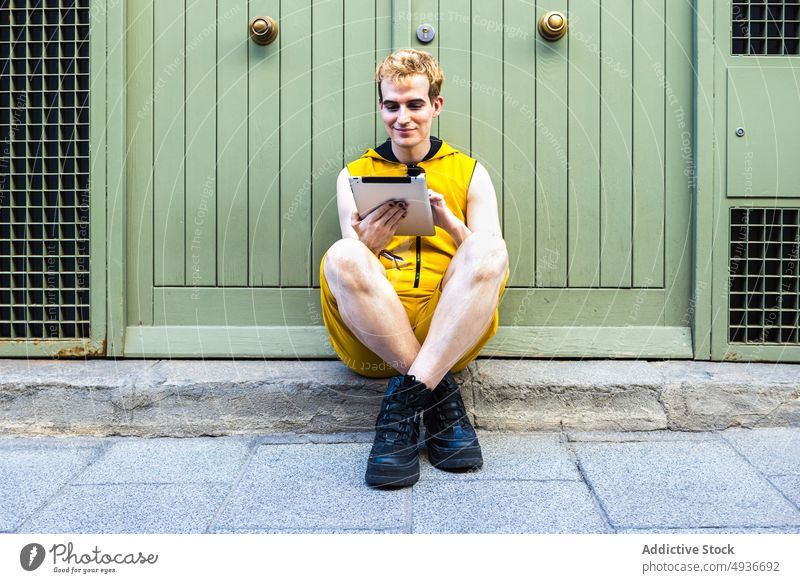Nicht binärer Mann mit Tablette benutzend Straße nicht binär Transgender lgbt Abend online Haus männlich jung transsexuell Apparatur Gerät Internet Browsen