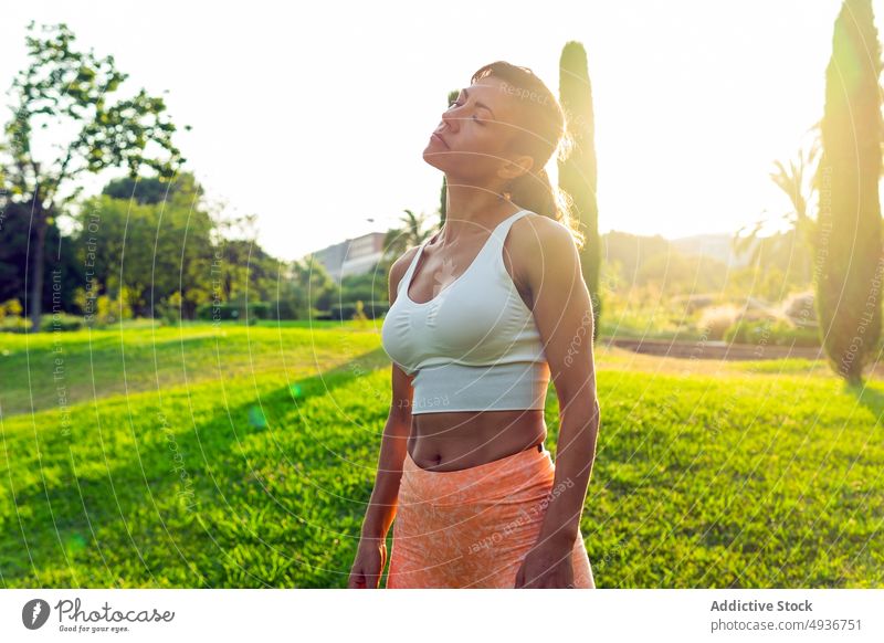Aktive Frau beim Aufwärmen in der Natur Training Dehnung Sport Landschaft Übung Fitness Aktivität üben Gesunder Lebensstil Sonnenlicht Ausdauer Gras Vitalität