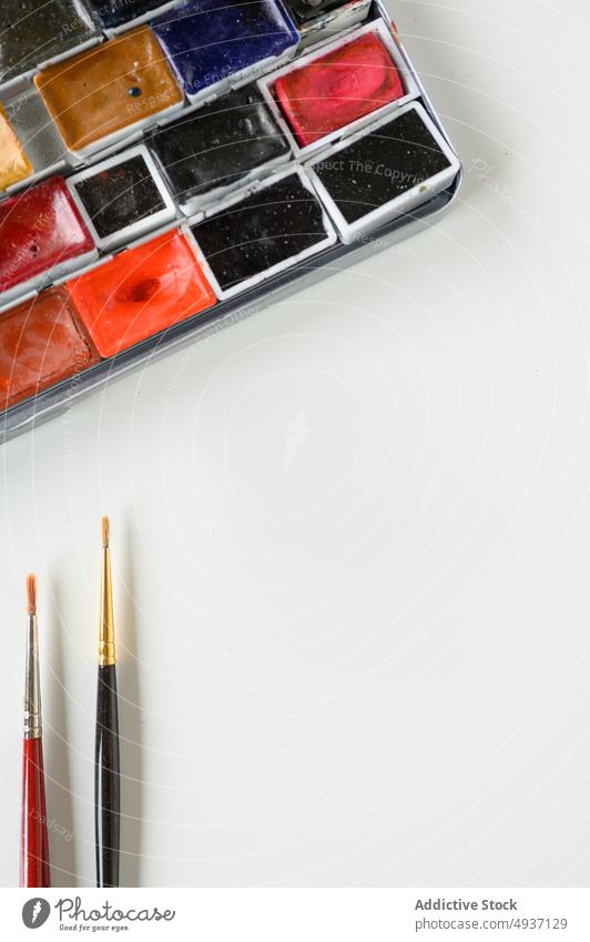 Plastikpaletten mit trockenen Malfarben und Pinseln Palette Fleck Farbe trocknen mischen farbenfroh kreativ Bürste Werkstatt Tisch Kunst vorbereiten