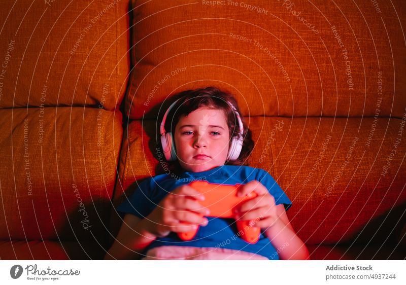 Unglückliches Mädchen spielt ein Videospiel am Abend Kind Wohnzimmer spielen unterhalten Vergnügen Zeitvertreib verärgert traurig unglücklich unzufrieden