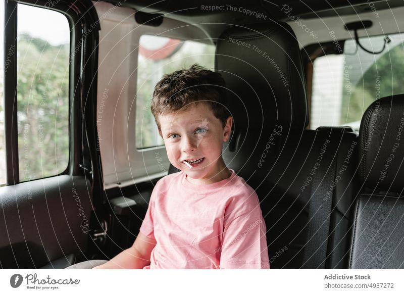 Junge schaut während einer Autofahrt in die Kamera Fenster PKW Autoreise Landschaft Rücksitz Passagier Wochenende Mitfahrgelegenheit Natur Ausflug Kindheit