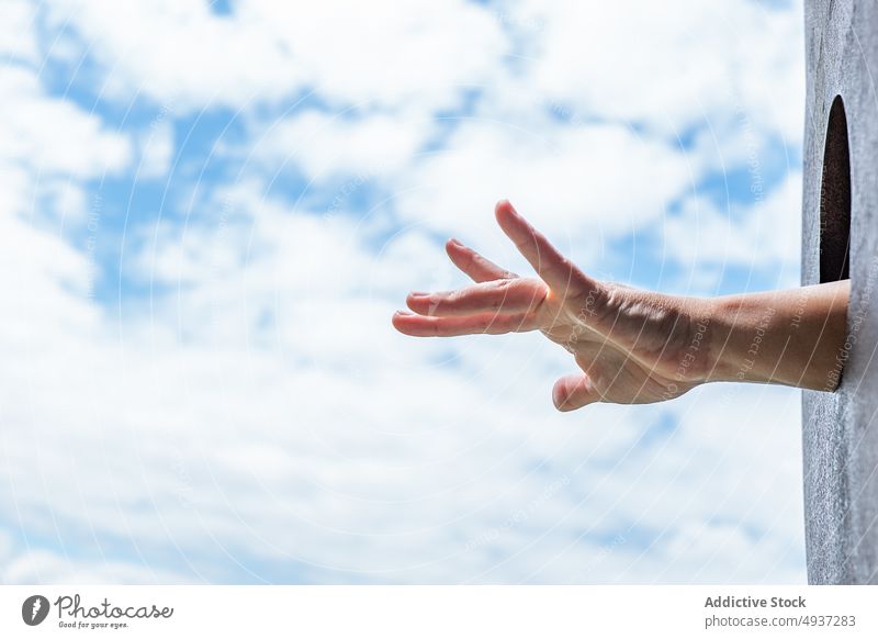Crop-Person, die ihre Hand aus dem Loch streckt rausstrecken Golfloch Spielplatz Blauer Himmel wolkig Wochenende Sommer Park tagsüber zeigen ausdehnen rund