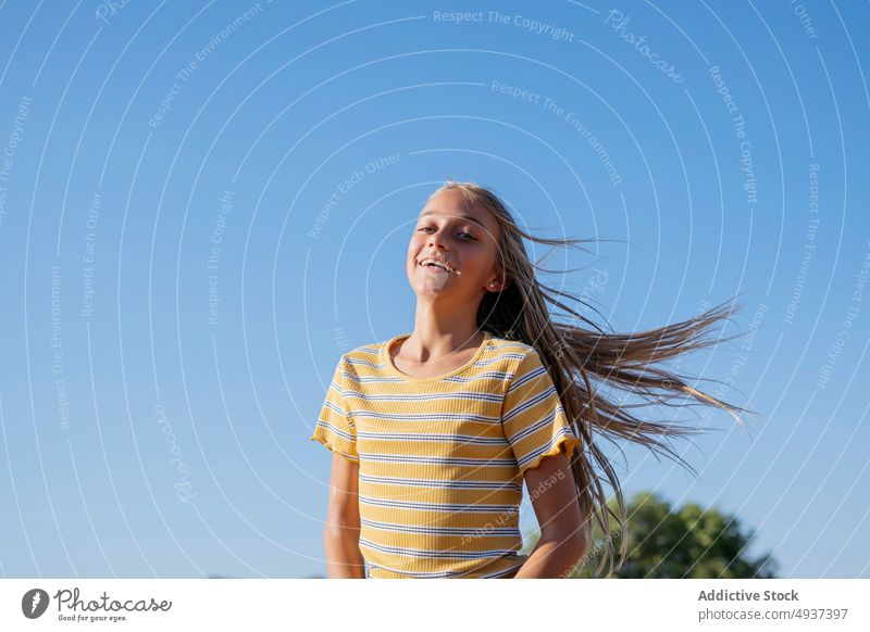 Inhalt Mädchen mit fliegenden Haaren Teenager fliegendes Haar Straße Vorschein Großstadt sorgenfrei Stil Lächeln Wind froh Blauer Himmel Sommer positiv Porträt