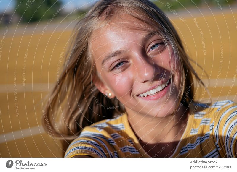 Lächelndes Mädchen nimmt Selfie auf der Straße Teenager Selbstportrait Fotografie Großstadt soziale Netzwerke Glück Kind heiter positiv Spielplatz Optimist froh