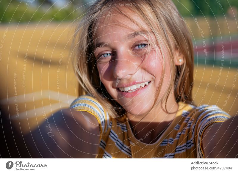 Lächelndes Mädchen nimmt Selfie auf der Straße Teenager Selbstportrait Fotografie Großstadt soziale Netzwerke Glück Kind heiter positiv Spielplatz Optimist froh