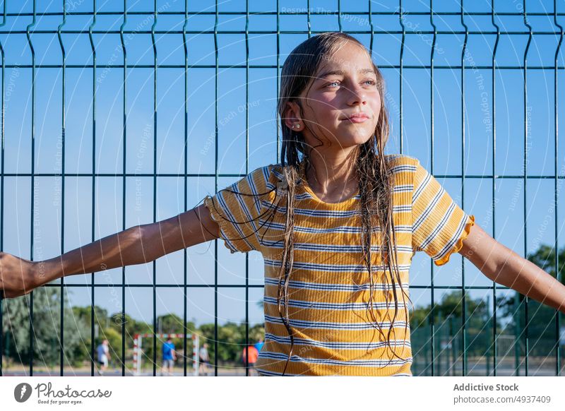 Mädchen in der Nähe des Tores auf dem Spielplatz Teenager Netz Gate Zeitvertreib Sportpark nasses Haar Freizeit Straße Sommer Sommerzeit Kind Sonnenlicht