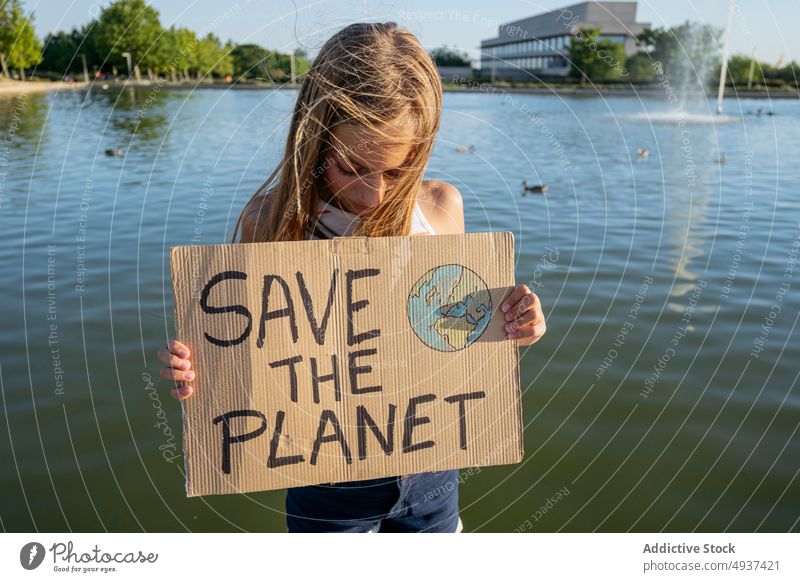 Mädchen mit Save The Planet-Schild in der Nähe des Flusses den Planeten retten Wasser Straße Aktivist Ökologie Aufmerksamkeit Problematik Krise Teenager