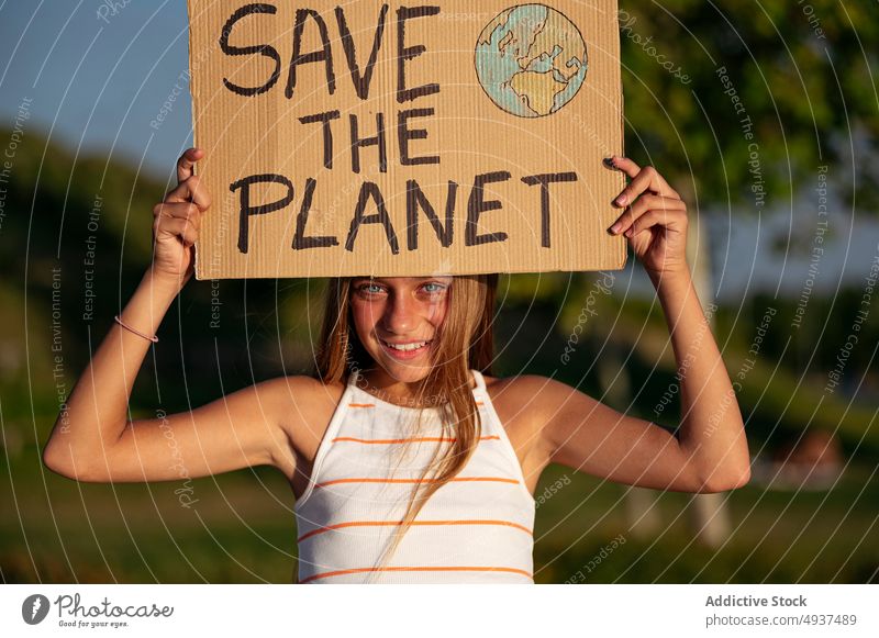 Mädchen mit "Save The Planet"-Schild auf einem Straßenparkplatz den Planeten retten Aktivist Ökologie Aufmerksamkeit Glück Problematik Krise Teenager Park