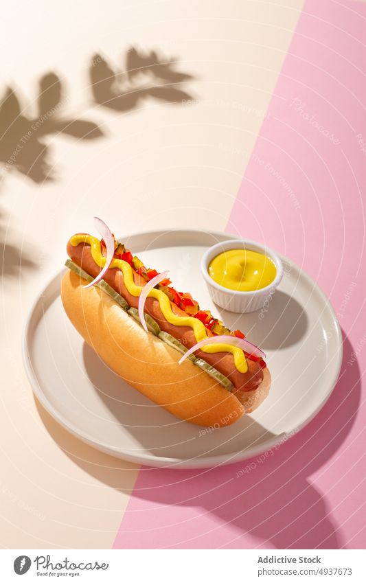 Hot Dog in einem runden Teller auf weißem und rosa Hintergrund heiß Hund Ketchup Mahlzeit Senf frankfurter Mittagessen Fleisch Lebensmittel Snack schnell fett