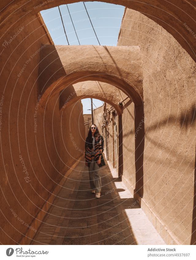 Ernste Frau in einem gewölbten Durchgang während einer Besichtigungstour in Kerman Sightseeing Ausflug historisch antik Architektur bewundern Tourist Urlaub