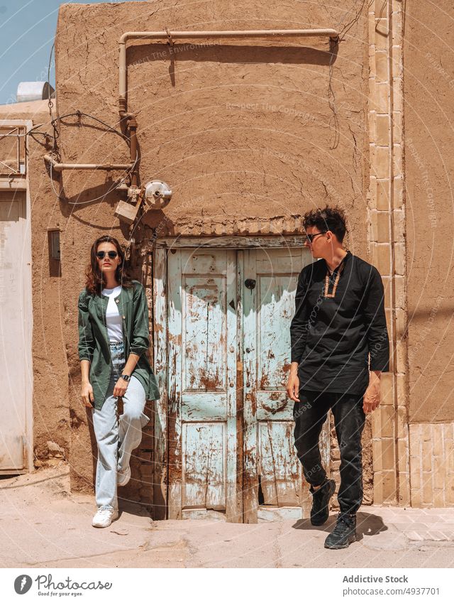 Junges stilvolles Paar steht in der Nähe eines alten Gebäudes während einer Reise in den Iran Zusammensein reisen Partnerschaft Ausflug Tourist Stadt Stil