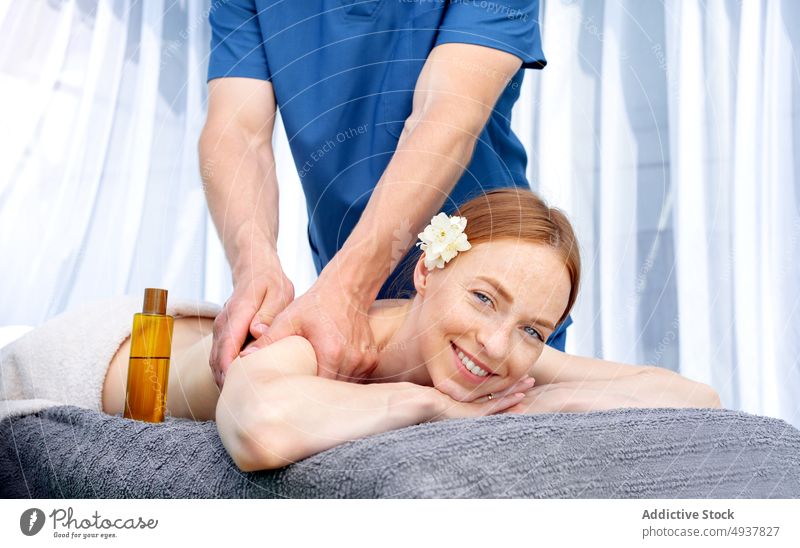 Frau schaut bei der Massage in die Kamera Klient rote Haare Masseur Spa Resort Wochenende Glück Lächeln Sitzung Erdöl Verfahren Mann Wellness Leckerbissen