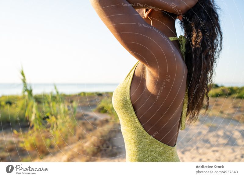 Crop schwarze Frau macht Haare am Strand Tourist MEER Ufer Geflecht Sommer Wochenende Stil reisen tagsüber Afroamerikaner ethnisch Küste gewelltes Haar