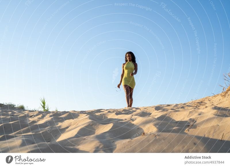 Stilvolle schwarze Frau geht am Sandstrand spazieren Spaziergang Strand Blauer Himmel Wochenende Sommer Resort Tourist jung Afroamerikaner Wolkenloser Himmel