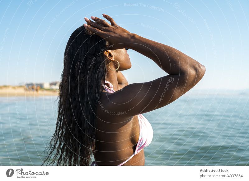Schwarze Frau im Meerwasser stehend Wasser MEER Resort Urlaub Badeanzug Sommer Blauer Himmel Morgen schwarz Afroamerikaner ethnisch Badebekleidung