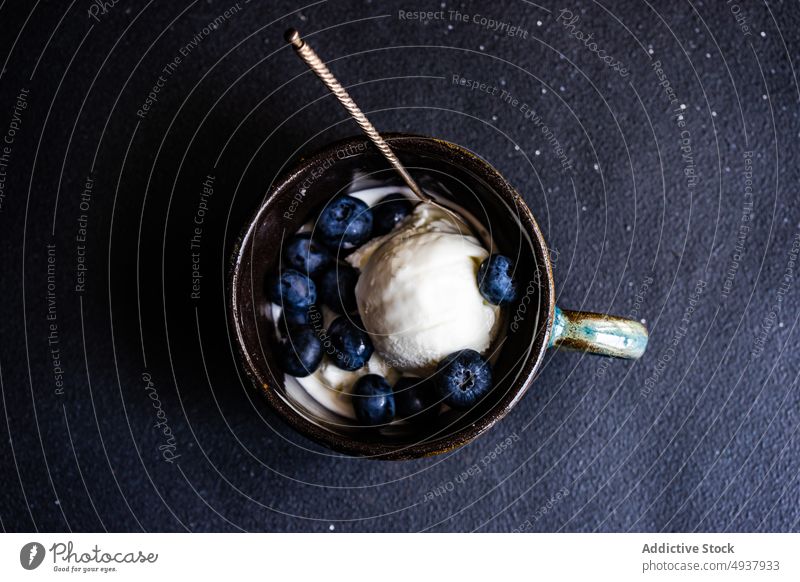 Sommerdessert mit Eis und Beeren Hintergrund Blaubeeren Baggerlöffel Schalen & Schüsseln Textfreiraum Tasse dunkel Dessert essen Lebensmittel Frucht gelato