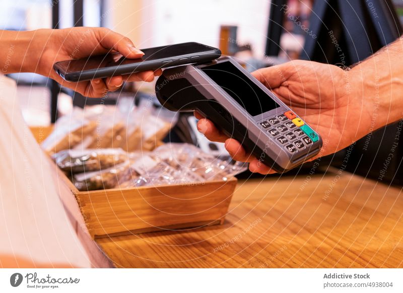 Erntehelferin beim Bezahlen von Waren in einem umweltfreundlichen Geschäft Klient Anbieter bezahlen Lebensmittelgeschäft Smartphone Terminal Laden berührungslos