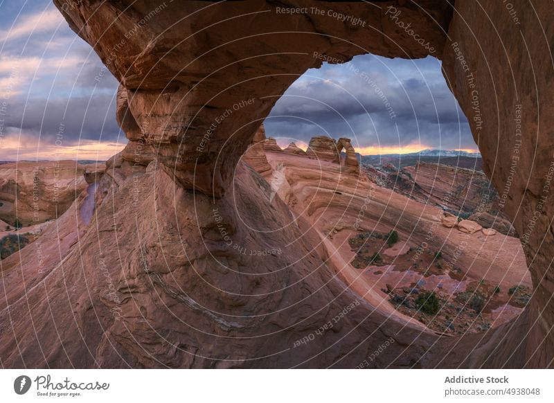 Natursteinbogen gegen bewölkten Himmel Bogen Stein Formation natürlich wolkig Sonnenuntergang Unwetter wüst trocken Delicate Arch Arches National Park Moab Utah