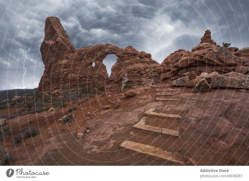 Treppe zum natürlichen Bogen während eines Gewitters Schritt wolkig Himmel Blitze Stein Formation Wahrzeichen Arches National Park Turret Arch Moab Utah USA
