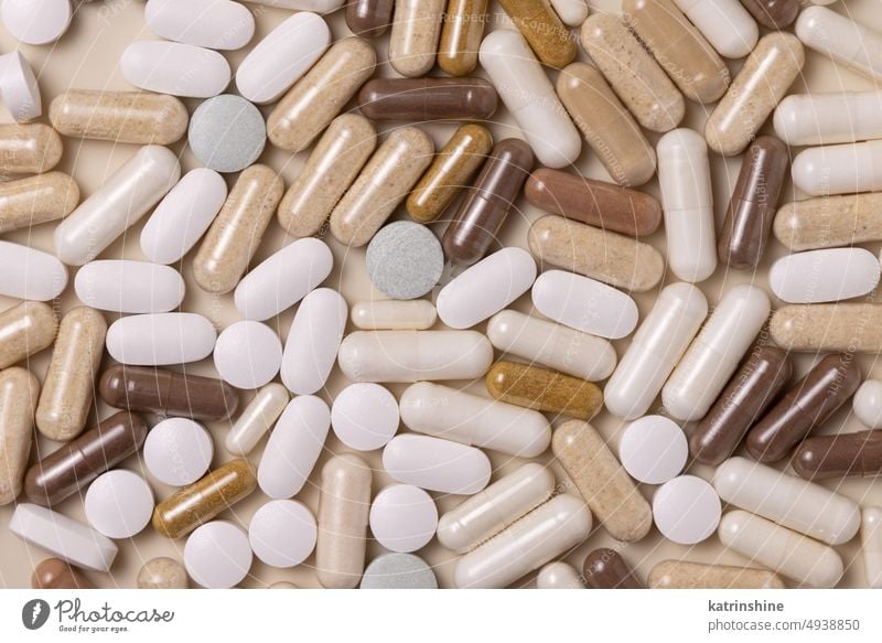 Mischung aus medizinischen Kapseln und Pillen auf hellbeiger Draufsicht. Einnahme von Nahrungsergänzungsmitteln Medizin Pharma Vitamine kreativ Apotheke