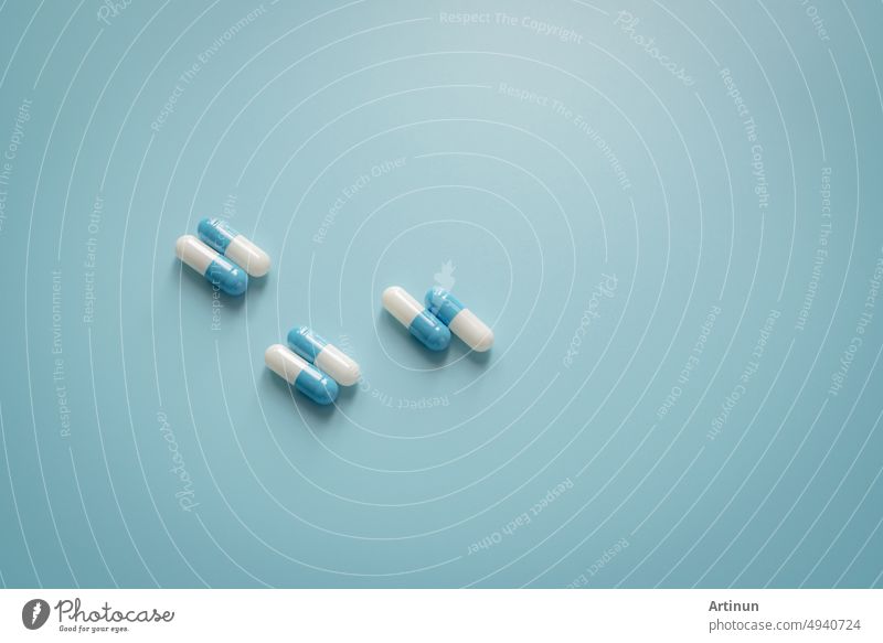 Paare von weiß-blauen Antibiotika-Kapseln auf blauem Hintergrund. Antibiotisches Medikament. Verschreibungspflichtiges Medikament. Pharmakologie und empfohlene Dosis Konzept. Pharmazeutische Industrie. Medizin und Gesundheitswesen Konzept.