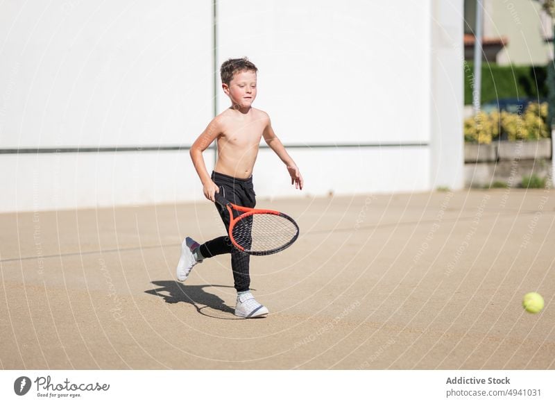 Hemdloser Junge spielt Tennis auf der Straße spielen Wochenende Spiel Glück Remmidemmi Sommer Kind tagsüber Sport Aktivität ohne Hemd Kindheit Ball Übung Hobby