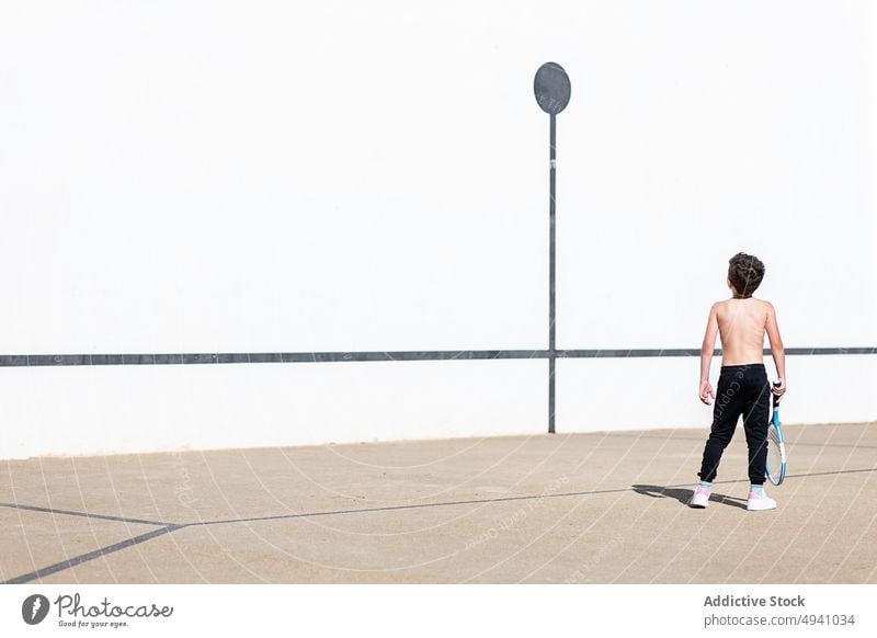 Anonymer Junge ohne Hemd spielt Tennis auf der Straße spielen Wochenende Spiel Remmidemmi Sommer Kind tagsüber Aktivität Kindheit Hobby Zeitvertreib sorgenfrei