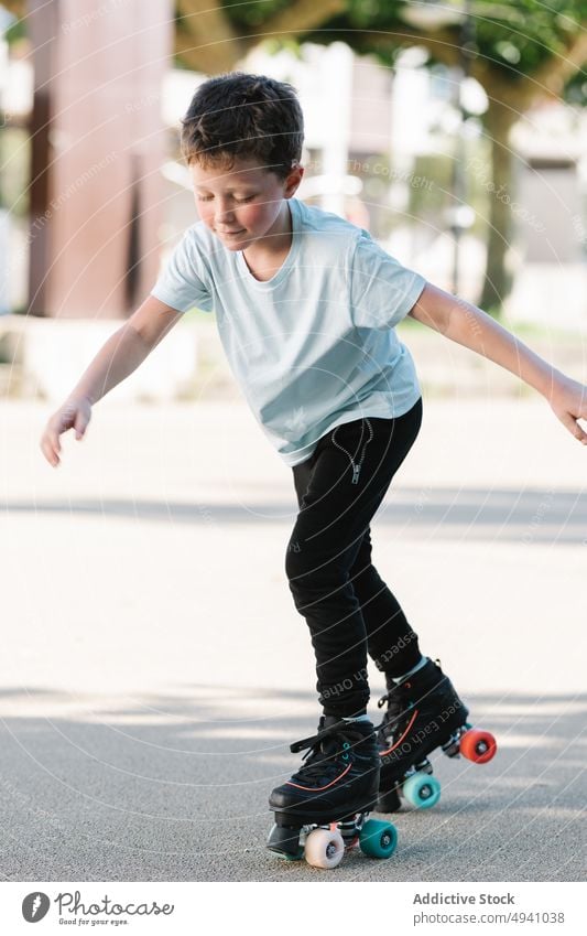 Junge fährt auf Rollschuhen auf der Straße Mitfahrgelegenheit Rollerskate Sommer Wochenende Aktivität Hobby tagsüber urban Kind Zeitvertreib lässig Kindheit