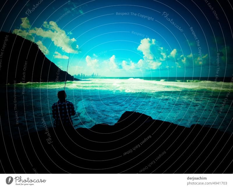 Ein Angler sitzt im Schatten am blauen Meeresstrand. Im Horizont links vom Hügel, die große Stadt am Meer sowie die Sonne mit weißen Wolken. # 1200 # Fischer