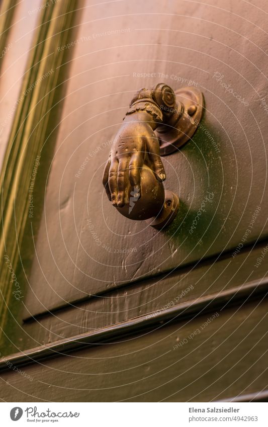 Vintage Türklopfer in einer Italienischen Altstadt. Hand antik vintage Messing Messingtürklopfer Türgriff faust kugel alt Eingang Griff