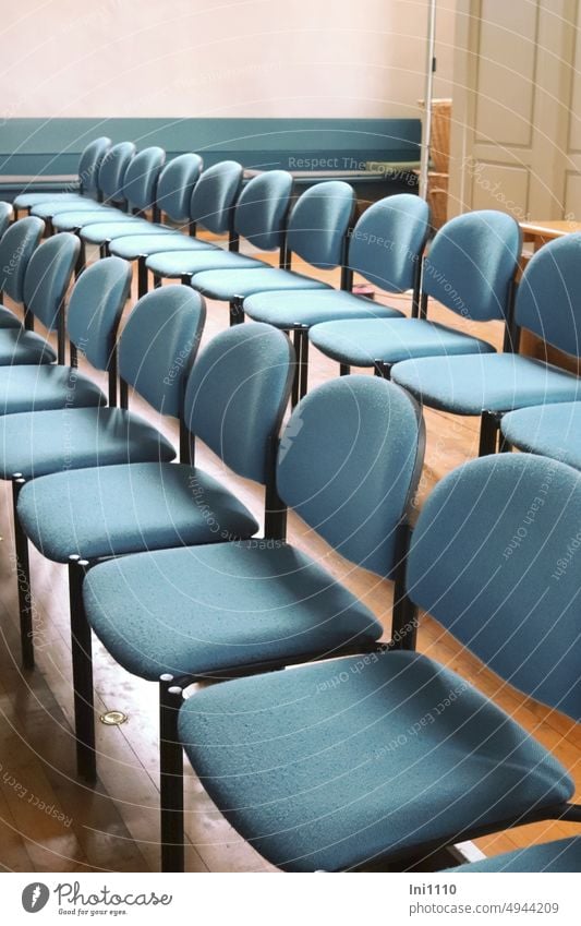 freie Sitzplätze Sitzmöbel Reihe Stuhlreihen leere Plätze Sitzgelegenheit Stühle Besucherstuhl Stapelstuhl ohne Armlehne Rückenlehne Sitzfläche gepolstert blau