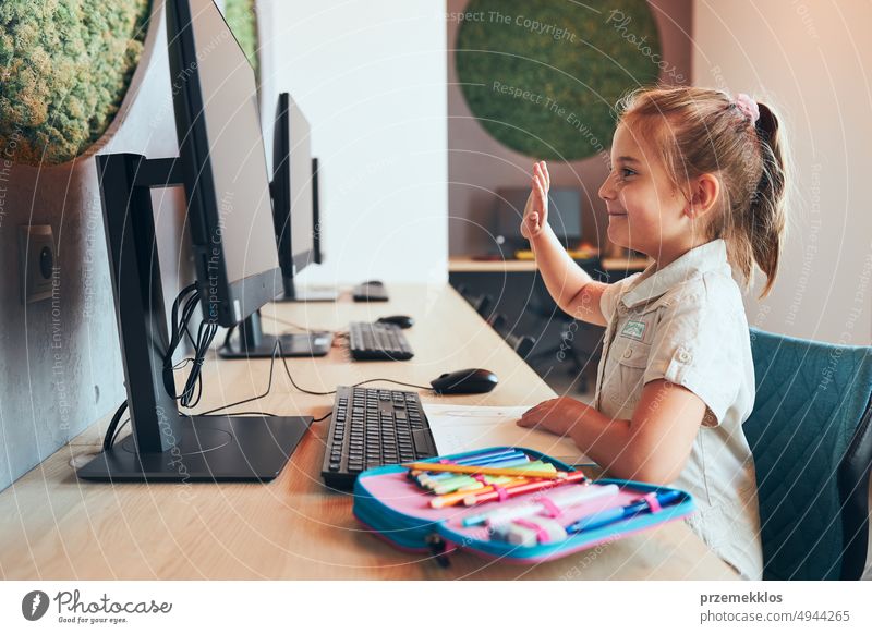 Student kleines Mädchen mit Video-Klasse aus der Ferne mit ihrem Lehrer auf dem Computer sitzen am Schreibtisch in nach der Schule Club in der Grundschule. Zurück zur Schule