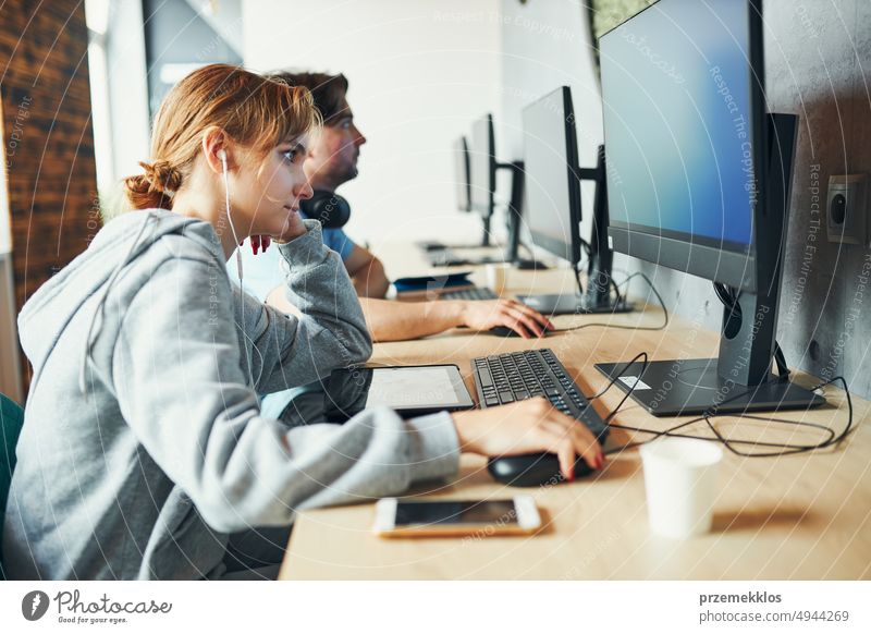 Studenten lernen im Computer-Klassenzimmer. Junger Mann bereitet sich am Computer auf einen Test vor. Mädchen schreibt Aufsatz und macht Notizen am Computer. Konzentrierte Studenten lernen für College-Prüfungen
