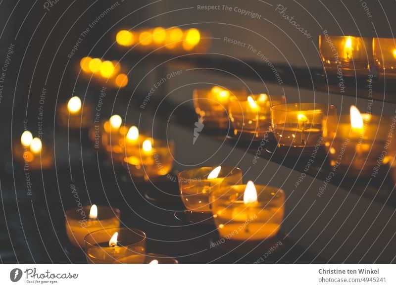 Kerzen der Hoffnung, der Trauer, der Dankbarkeit in einer Kirche brennende Kerzen Christentum Kerzenschein Gedenken Gebet Licht erinnern Tod kerze anzünden