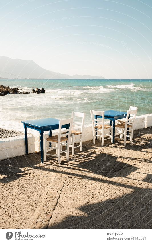 Terrasse eines griechischem Restaurants direkt am Meer mit Blick auf die Berge Außenaufnahme Tisch und Stühle Griechenland Gastronomie leer Menschenleer