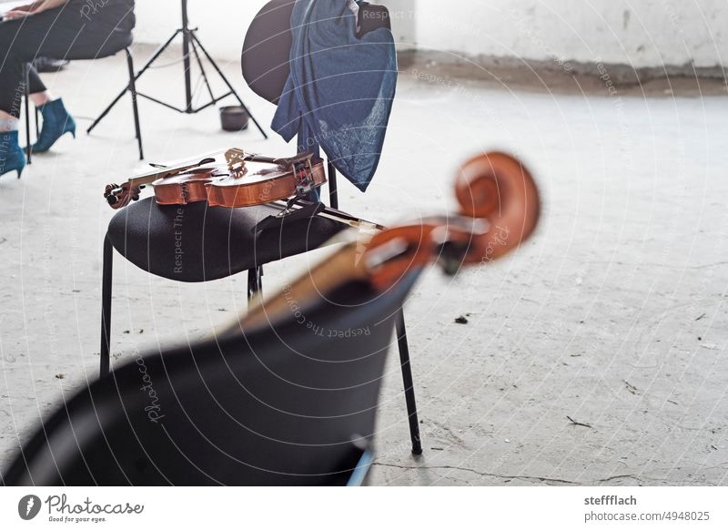 Pause bei der Probe Alter Musik in einem verlassenen Industrieloft Geige Geigen Stuhl Stühle Klassische Musik Alte Musik Loft Noten Notenständer Musikinstrument