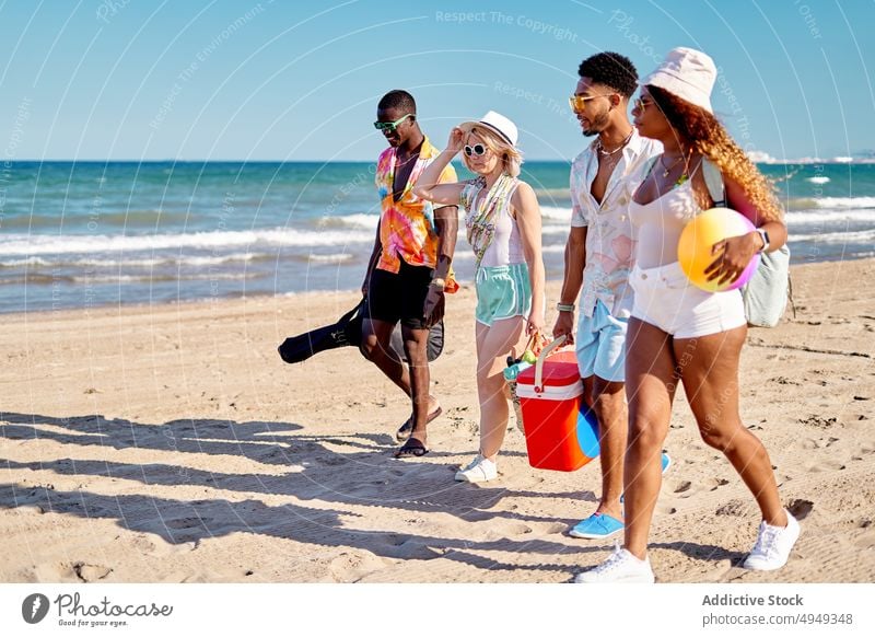 Verschiedene Freunde gehen am Strand spazieren Spaziergang Sommer Wochenende Zusammensein Sand Blauer Himmel Resort tagsüber Männer Frauen jung schlendern