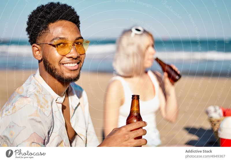 Schwarzer Mann trinkt Bier mit Freunden trinken Strand MEER Picknick Flasche Zusammensein Sitzung Wochenende Frau Sommer Alkohol Schnaps Getränk vielfältig