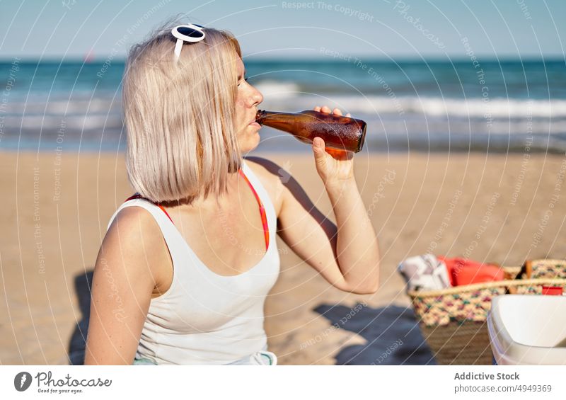 Junge Frau trinkt Bier am Strand trinken Wochenende Sommer Flasche Alkohol Picknick schlürfen jung blond Urlaub Sonnenbrille Getränk Feiertag Durst Sonnenlicht