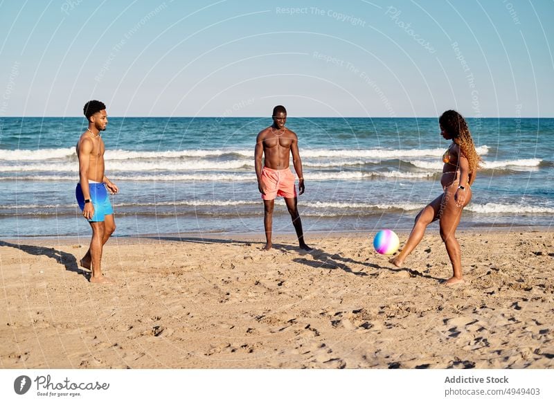 Verschiedene Freunde spielen mit einem Wasserball Ball Strand Zusammensein MEER aufschlagen Fliege Wochenende Sommer Männer Frauen jung vielfältig