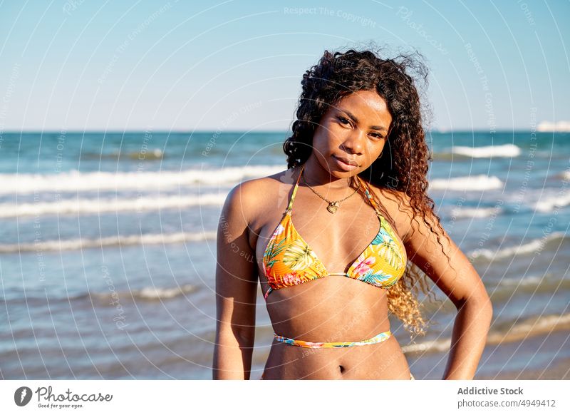 Fröhliche schwarze Frau am Meer Strand MEER Lächeln Tourist Wochenende Glück Bikini Sommer Urlaub winken Resort Afroamerikaner ethnisch Feiertag Optimist froh