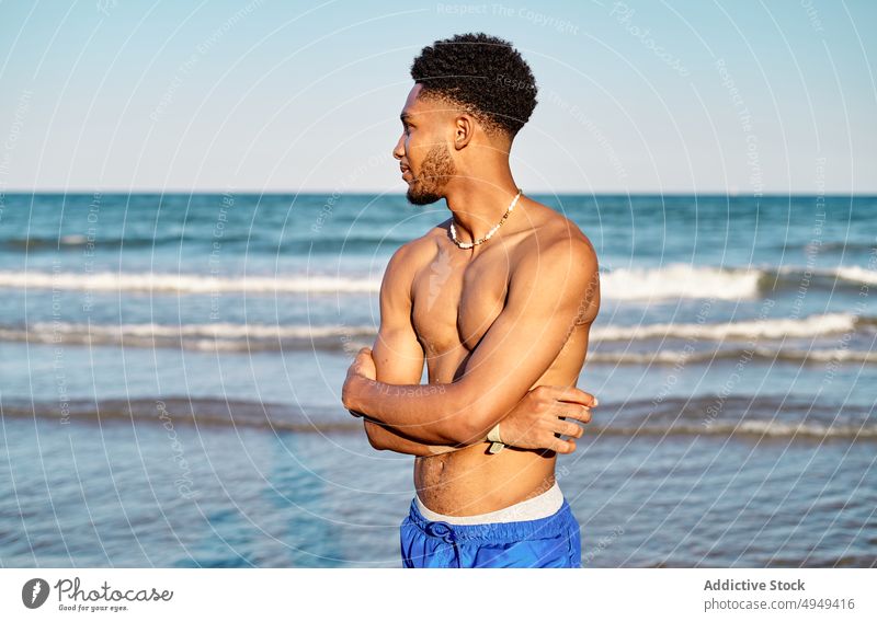 Schwarzer junger männlicher Tourist steht am Meer Mann Strand MEER Sommer Wochenende krause Haare Resort Urlaub nachdenklich Feiertag Porträt Küste Ufer
