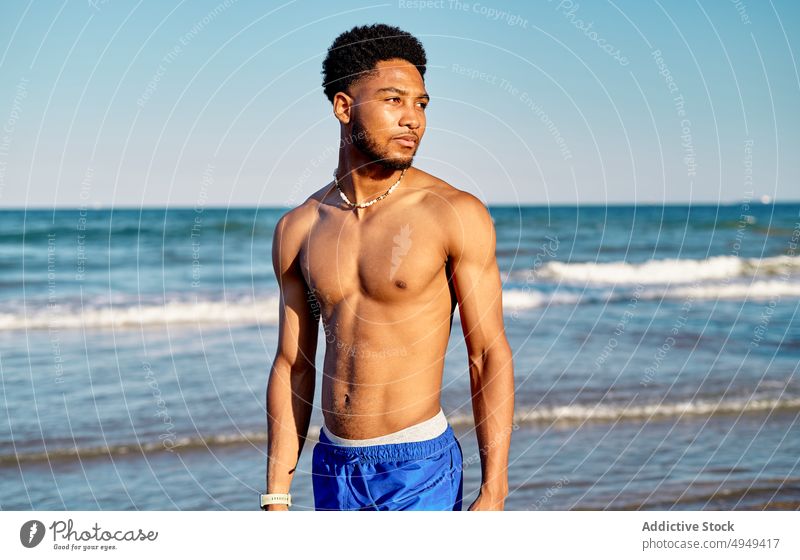 Schwarzer junger männlicher Tourist steht am Meer Mann Strand MEER Sommer Wochenende krause Haare Resort Urlaub nachdenklich Feiertag Porträt Küste Ufer