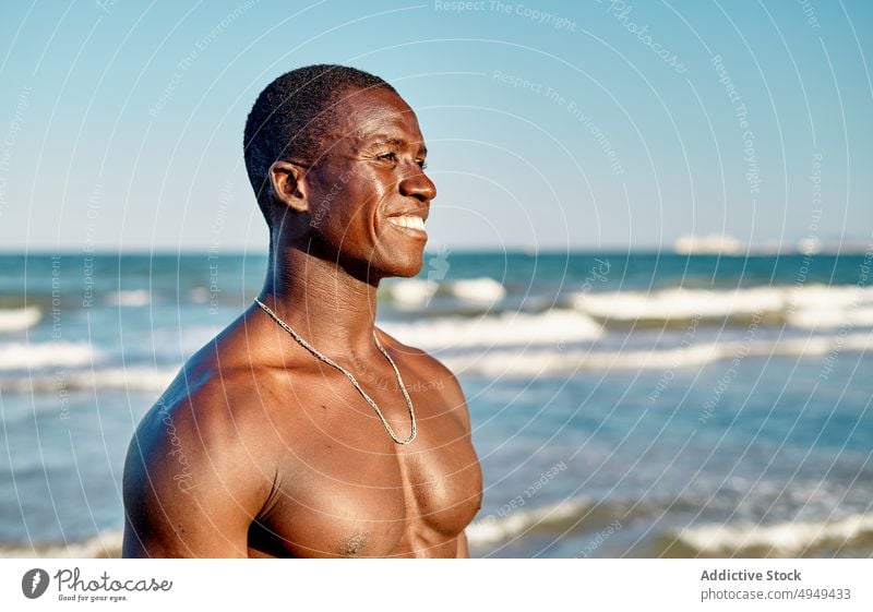 Fröhlicher schwarzer Mann lächelnd am Meer Lächeln Strand MEER Glück Wochenende Sommer Blauer Himmel heiter Wasser männlich Afroamerikaner ethnisch freundlich