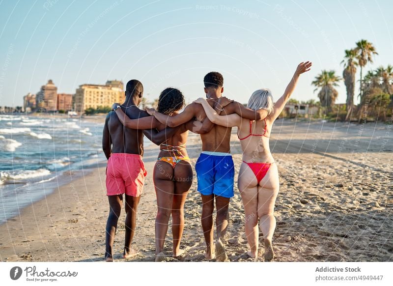 Anonyme, fröhliche, diverse Freunde, die sich am Strand umarmen Umarmung Wochenende Sommer Spaziergang Zusammensein Glück Urlaub Resort Männer Frauen Umarmen
