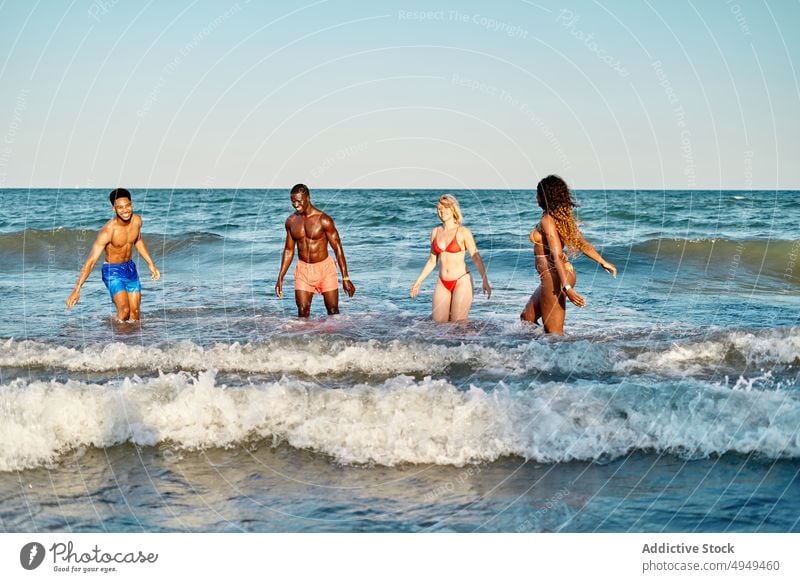 Multirassische Freunde spielen im Meerwasser Sommer MEER Wochenende Wasser Strand Zusammensein winken Männer Frauen vielfältig rassenübergreifend multiethnisch